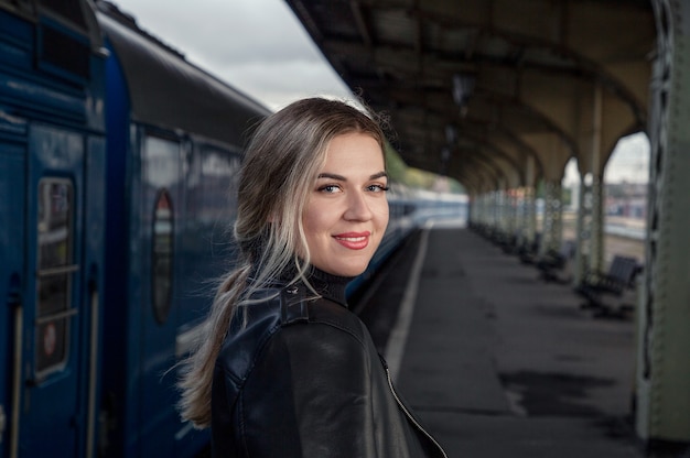 Jeune belle fille souriante sur le quai de la gare