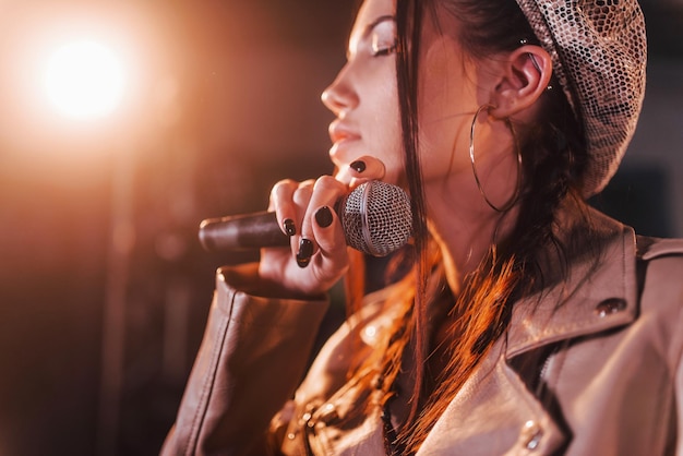 Jeune belle interprète féminine répétant dans un studio d'enregistrement