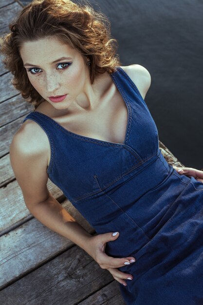 Jeune belle mannequin posant sur la jetée