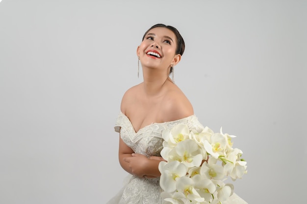 Photo jeune belle mariée asiatique pose avec une sensation excitée sur fond blanc