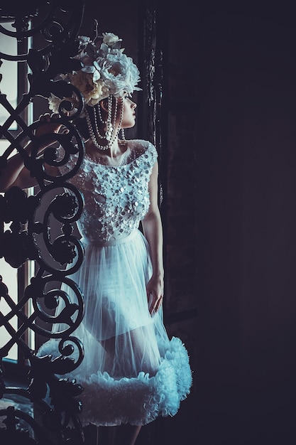 Jeune belle mariée brune debout dans la salle du palais