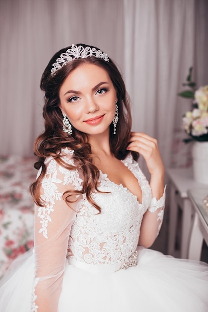 Jeune belle mariée avec une coiffure et un maquillage de mariage brune