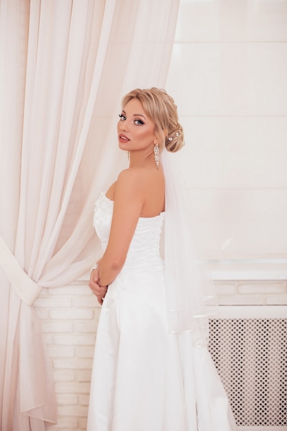 Jeune belle mariée avec une coiffure de mariage blonde