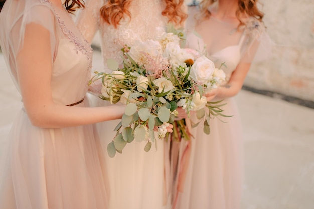 Jeune belle mariée posant en robe de mariée avec bouquet