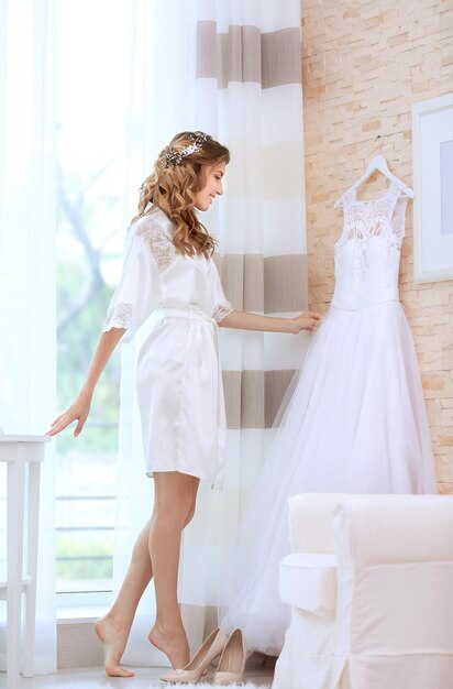 Jeune belle mariée avec robe de mariée dans la chambre