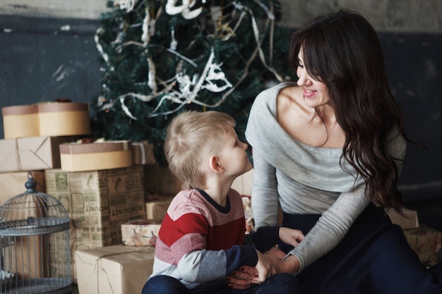 Jeune belle mère avec le fils près de l'arbre de Noël