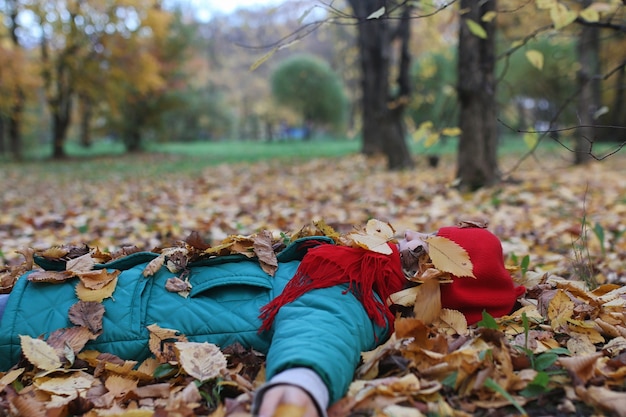 Jeune belle mère avec sa fille sur la nature. Une fille au chapeau se promène dans le parc. Fille dans le parc de la ville d'automne à la chute des feuilles.