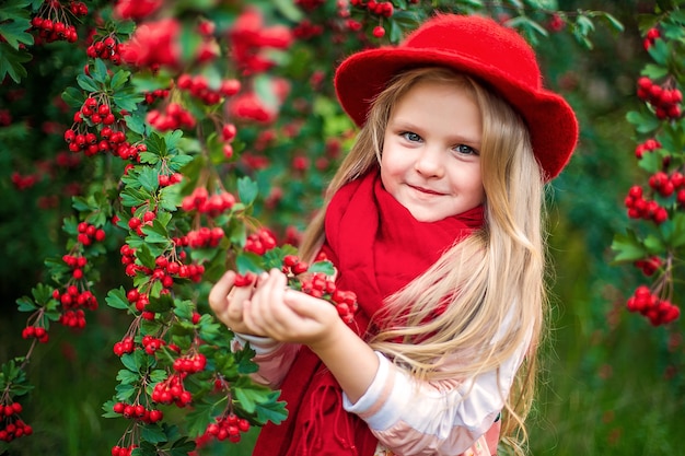 Jeune belle petite fille chic dans un parc d'automne ensoleillé