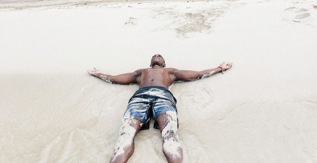 Jeune black allongé sur le sable