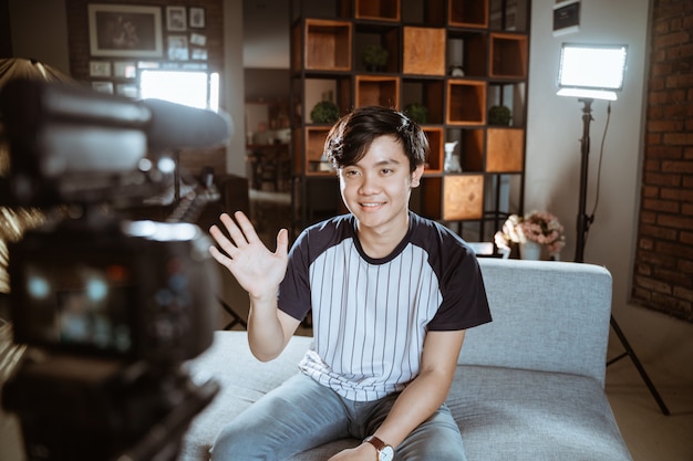 Jeune blogueur asiatique faire un examen à l'aide de l'appareil photo au premier plan