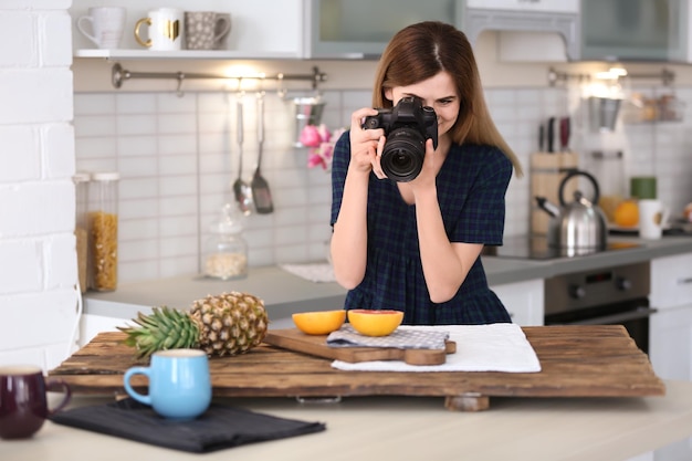 Jeune blogueur prenant une photo de nourriture dans la cuisine