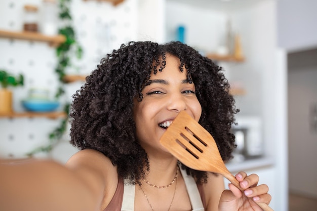 Jeune blogueuse culinaire afro-américaine prenant un selfie avec un soudeur