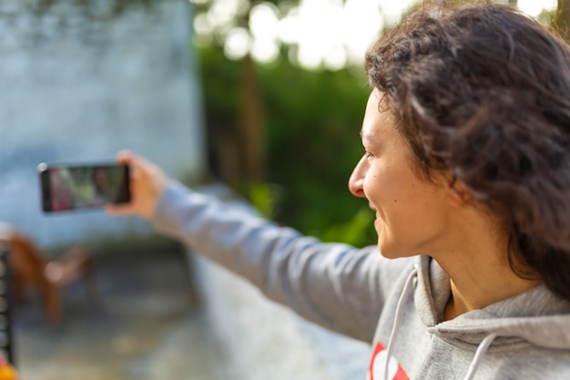 Une jeune blogueuse se prend en photo avec un téléphone. Reportage vidéo du blogueur.