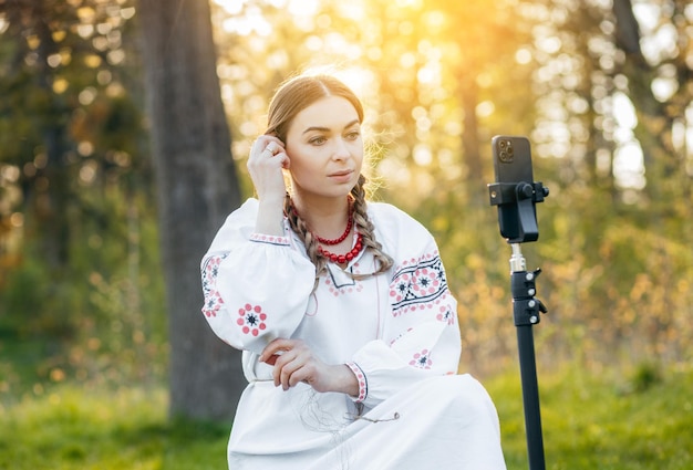 Jeune blogueuse ukrainienne en costume national filmant une vidéo au téléphone lors d'un voyage en fo