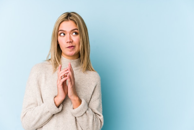 Jeune blonde caucasienne femme isolée constituant le plan à l'esprit, la mise en place d'une idée.