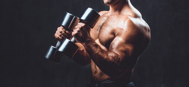 Jeune bodybuilder sur fond noir