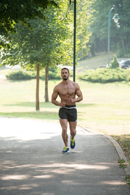 Jeune Bodybuilder s'exécutant dans la zone du parc de la formation et de l'exercice pour Trail Run Marathon Endurance Fitness Mode de vie sain Concept