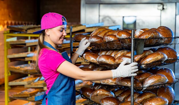 Jeune boulanger élégant travaillant avec du pain Aliments frais de production Four d'usine