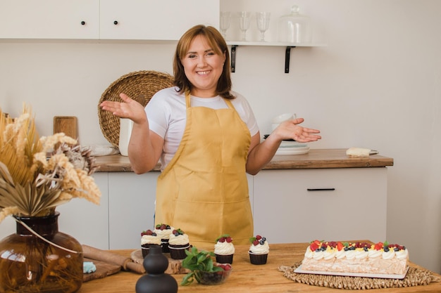 Jeune boulanger femme tenant des cupcakes