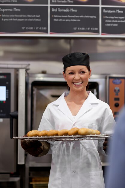 Jeune boulanger gai avec des baguettes