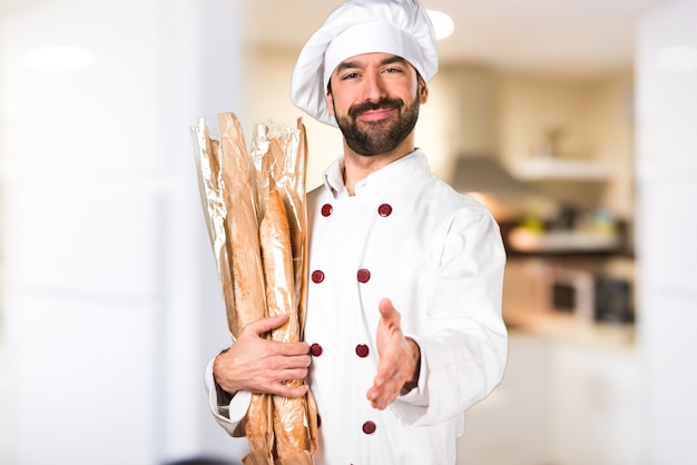 Le jeune boulanger prend du pain et fait une affaire dans la cuisine