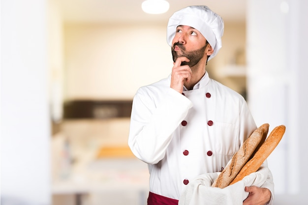 Le jeune boulanger prend du pain et pense à la cuisine