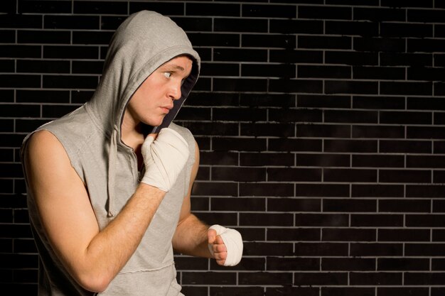 Jeune boxeur déterminé dans un sweat à capuche