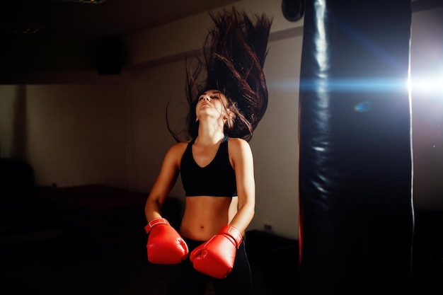 Une jeune boxeuse lance ses cheveux en s'entraînant au gymnase.