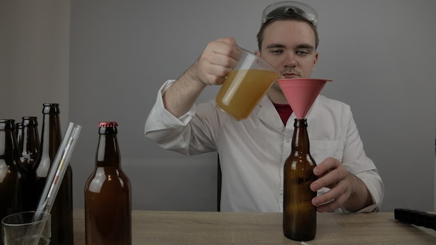 Un jeune brasseur prépare les produits et vérifie la qualité du matériel et la qualité de la bière au miel brassée à domicile