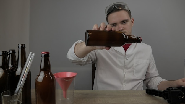 Un jeune brasseur prépare les produits et vérifie la qualité du matériel et la qualité de la bière au miel brassée à domicile