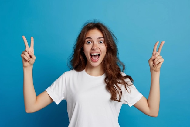 Une jeune brune européenne sympathique et réussie dans un T-shirt blanc sur fond bleu s'exclame exci