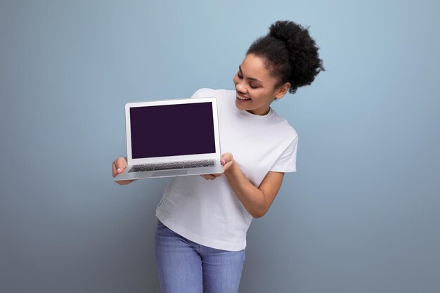 Photo une jeune brune latine en t-shirt blanc qui étudie à distance en utilisant un ordinateur portable