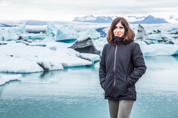 Une jeune brune touriste sur le lac gelé de Jokulsarlon en août Islande