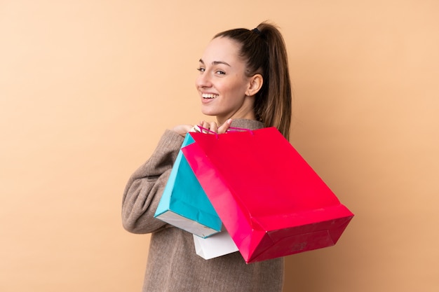 Jeune, brunette, femme, isolé, mur, tenue, achats, sacs, Sourire