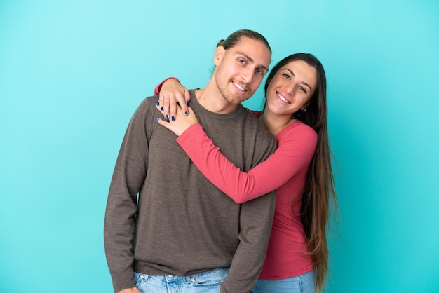 Jeune, caucasien, couple, isolé, sur, fond bleu, étreindre