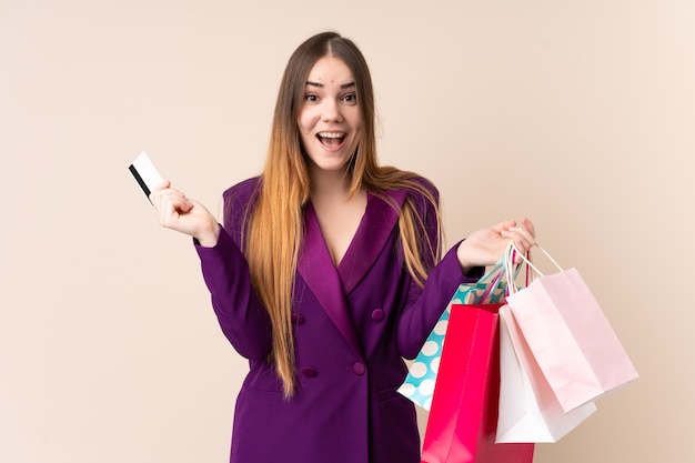 Jeune, caucasien, femme, isolé, beige, mur, tenue, achats, sacs, carte de crédit