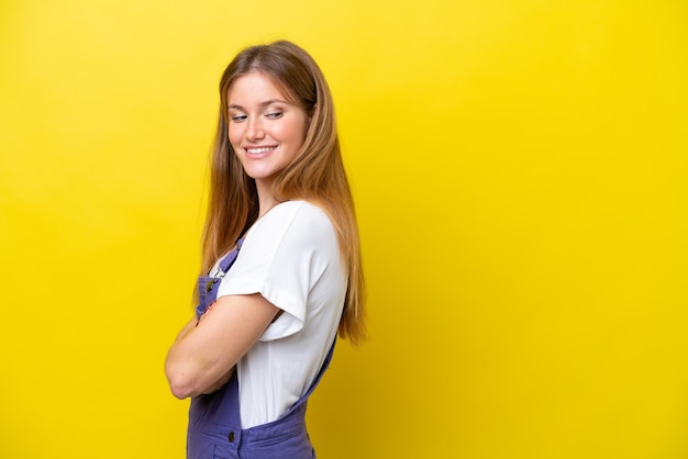 Jeune, caucasien, femme, isolé, sur, fond jaune, regarder côté, et, sourire