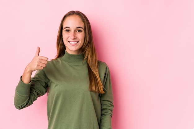 Jeune, caucasien, femme, poser, isolé, sourire, et, élévation, pouce haut