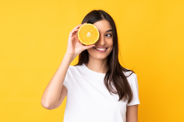 Jeune, caucasien, femme, tenue, orange, jaune, mur