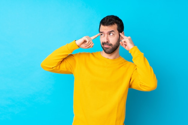 Jeune, caucasien, homme, isolé, bleu, mur, avoir, doutes, pensée