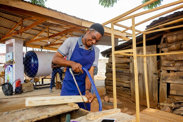 Photo jeune charpentier africain debout tenant le travail