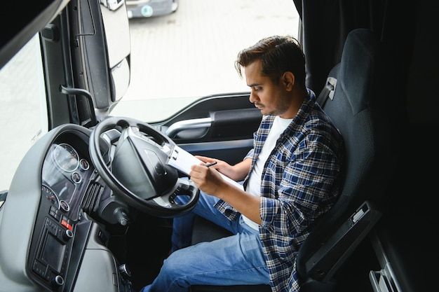 Photo un jeune chauffeur de camion indien est assis derrière le volant.