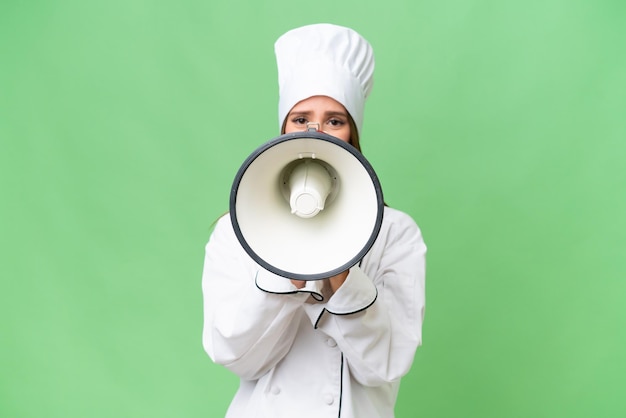 Jeune chef caucasien femme sur fond isolé criant à travers un mégaphone