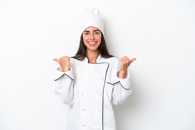 Jeune chef femme sur fond blanc avec le geste du pouce levé et souriant