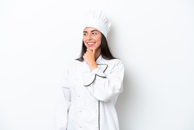 Jeune chef femme sur fond blanc regardant sur le côté