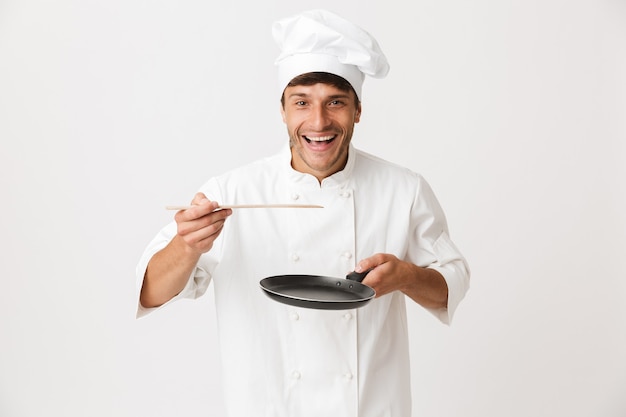 Jeune Chef Homme Debout Isolé Sur Mur Blanc Tenant La Vaisselle.