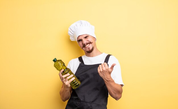 jeune chef avec moustache avec bouteille d'huile d'olive