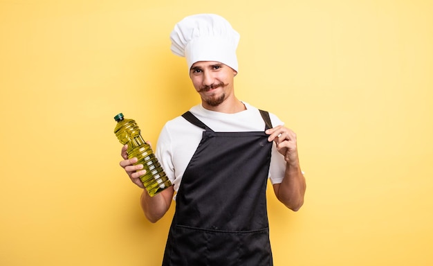 jeune chef avec moustache avec bouteille d'huile d'olive