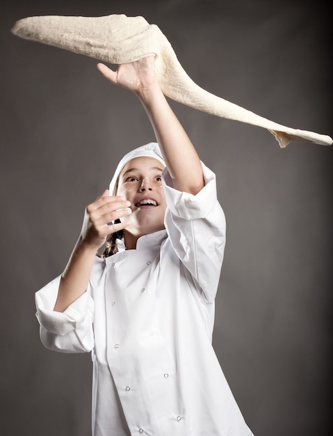 jeune chef travaillant la pâte à pizza