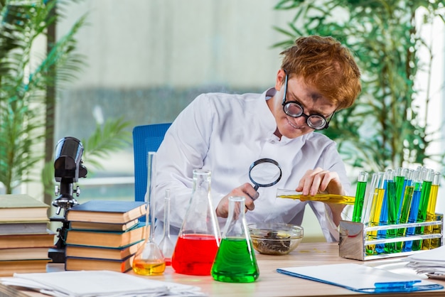 Jeune chimiste fou travaillant dans le laboratoire